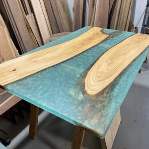 example table of elm slabs with lots of epoxy that is a translucent colour showing off the seafoam colour
