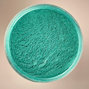 green colour with emerald shimmer showcasing a fine mica powder from a top view of a container